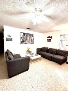 sala de estar con 2 sofás y ventilador de techo en Miami House en Miami