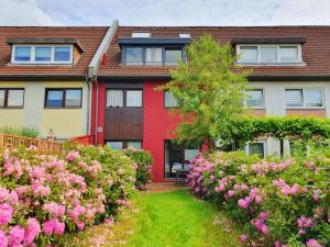 une maison avec des fleurs roses devant elle dans l'établissement Aparthotel Jonas, à Brême