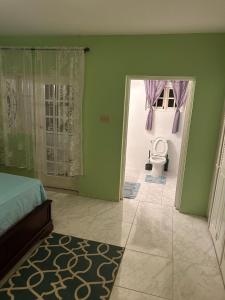 a bedroom with a bed and a bathroom with a toilet at Jamaica Villa By The Sea in St Mary