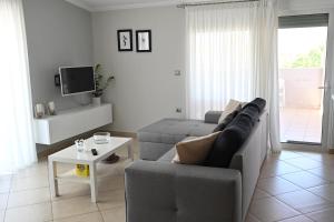 uma sala de estar com um sofá e uma mesa em Vasiliki’s Guesthouse em Atenas