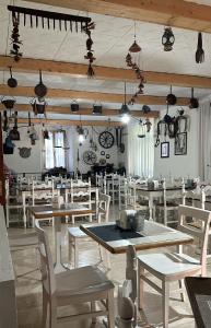 una sala da pranzo con tavoli in legno e sedie bianche di Albergo Varone a Riva del Garda
