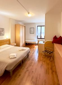 um quarto com uma cama, uma secretária e uma janela em Albergo Varone em Riva del Garda