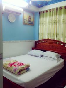 Schlafzimmer mit einem großen Bett mit einem Kopfteil aus Holz in der Unterkunft Phú Thông in Chau Doc