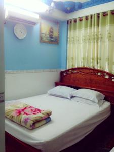 a bedroom with a large bed with a wooden headboard at Ph&uacute; Th&ocirc;ng in Chau Doc