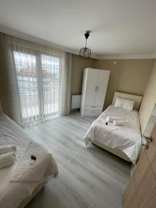 a bedroom with two beds and a large window at Anatolia SUITE APART in Bostancı