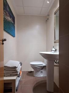 a white bathroom with a sink and a toilet at La Bonita Ador Apartamento in Ador