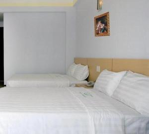 two beds in a hotel room with white sheets at Phú Thông in Chau Doc +11 photos