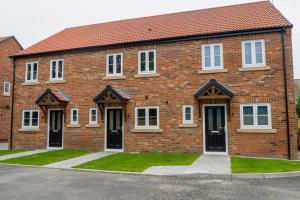 a brick building with white windows and black doors at Short Stays, Free Parking, Contractors, Families - Large Home in Durham