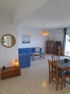 a living room with a blue couch and a table at Χαλκιδική Κρυοπηγή in Kriopigi