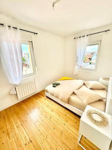 - une chambre avec un lit et 2 fenêtres dans l'établissement Le Cosy T2 15 min de Strasbourg, à Bischheim