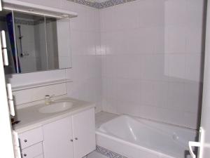 ein weißes Badezimmer mit Waschbecken und Badewanne in der Unterkunft Appartement dans résidence, plage et centre ville à pied in Saint-Jean-de-Luz