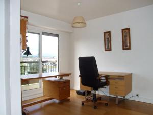ein Büro mit einem Schreibtisch, einem Stuhl und einem Fenster in der Unterkunft Appartement dans résidence, plage et centre ville à pied in Saint-Jean-de-Luz