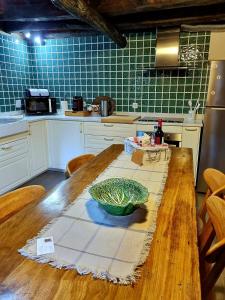 a kitchen with a wooden table with a bowl on it at Casa Ferreira-Talasnal in Talasnal +23 photos