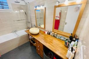ein Badezimmer mit einem Waschbecken, einem Spiegel und einer Badewanne in der Unterkunft Charming House Ideally Located With Furnished Terrace 3 Bedrooms & Parking in Le Bouscat