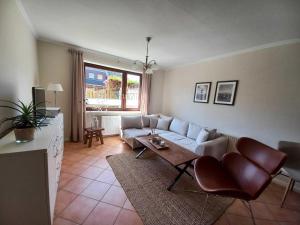 un soggiorno con divano e tavolo di Johannsen-Huis-Appartement-Bent a Tinnum