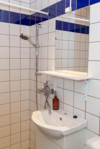 ein Bad mit einem Waschbecken und einem Spiegel in der Unterkunft Pension Slægtsgaarden in Allinge