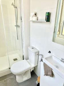 La salle de bains blanche est pourvue de toilettes et d'un lavabo. dans l'établissement Le Cosy T2 15 min de Strasbourg, à Bischheim