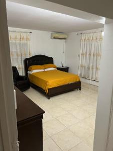 1 dormitorio con 1 cama y 1 silla en Jamaica Villa By The Sea, en Saint Mary