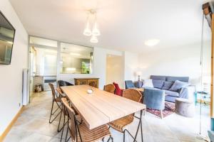 eine Küche und ein Wohnzimmer mit einem Holztisch und Stühlen in der Unterkunft 3-bedroom flat in the city centre in Chamonix-Mont-Blanc