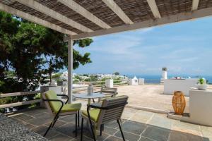 a patio with a table and chairs and the ocean at Sunrise balcony in Sifnos