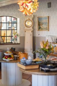 a clock in a room with a table with food at Pension Slægtsgaarden in Allinge