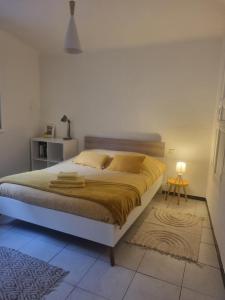 ル・ブールーにあるAppartement coquet Le Boulouのベッドルーム1室(大型ベッド1台、黄色い毛布付)