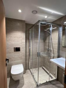 uma casa de banho com um chuveiro, um WC e um lavatório. em Arctic Hotel Nordkapp em Honningsvåg