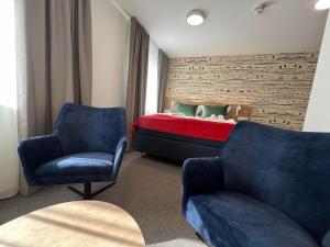 - une chambre avec un lit et deux chaises dans l'établissement Arctic Hotel Nordkapp, à Honningsvåg