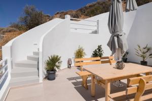 une terrasse avec une table en bois et un parasol dans l'établissement Captain's house suites, à Vóthon