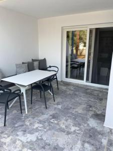 阿喬普羅柯皮歐斯的住宿－尼克萊塔一室公寓酒店，庭院里的白色桌椅