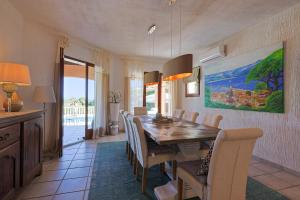 ein Esszimmer mit einem Holztisch und Stühlen in der Unterkunft Luxus Villa Cristina - mit Pool und Meerblick by Riviera HomeLife in Roquebrune-sur-Argens