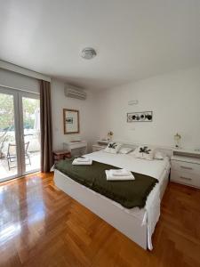 a bedroom with a large bed and a wooden floor at Villa Hosta Apartments in Hvar