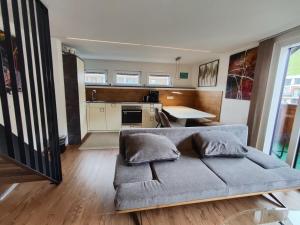 a living room with a couch and a kitchen at Alpinoase City Centre Zell am See in Zell am See