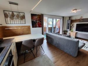 a living room with a couch and a table at Alpinoase City Centre Zell am See in Zell am See