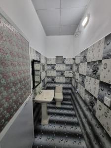 baño con lavabo y suelo blanco y negro en Nilaveli Guest House, en Nilaveli
