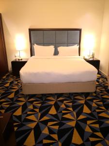 Ocean View Al Zahra في جدة: غرفة نوم بسرير كبير ومصباحين على الطاولات