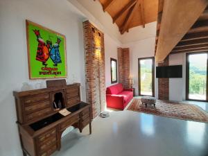 a living room with a red couch and a red chair at Madama Langa Country House con piscina nelle vigne in Montelupo Albese