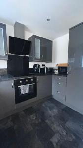 a kitchen with black and white counters and appliances at Florence house in Thornaby on Tees +5 photos