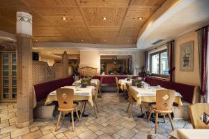 un restaurante con mesas y sillas en una habitación en Almhotel Lenz en Valdaora
