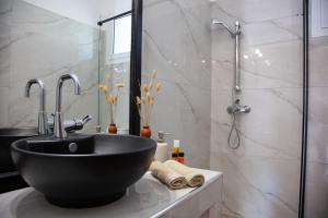 uma casa de banho com um lavatório preto e um chuveiro em Villa Primarosa em Metaxáta