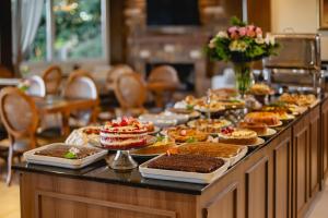 um buffet com sobremesas, bolos e tartes em Hotel Jardins da Colina em Nova Petrópolis