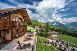 a group of chairs on a patio outside of a building at Almhotel Lenz in Valdaora
