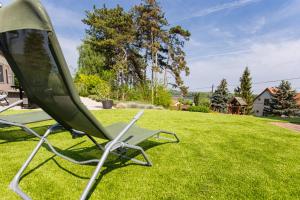 a green lawn chair sitting in a yard at Kulcsi-Duna Vendégház in Kulcs