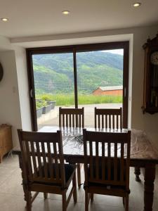 uma sala de jantar com uma mesa e cadeiras e uma janela em Appartement in the mountains em Bourg-Saint-Maurice