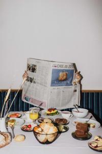 un tavolo ricoperto di piatti di cibo e un giornale di Thalguter - Rooms & Breakfast a Lagundo