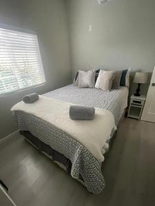 um quarto com uma cama com almofadas e uma janela em Van Nuys Luxury, near to Universal Studios, and Hollywood em Los Angeles
