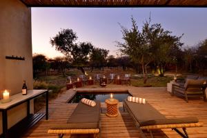 a patio with a pool and a table and chairs at Ngala Lodge in Klipdrift