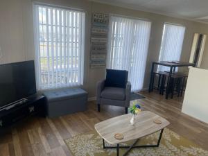 a living room with a tv and a table and a chair at Lakes edge view in Millom