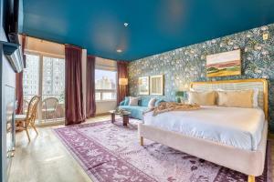 um quarto com uma cama grande e uma parede azul em Quest Travels em Seattle