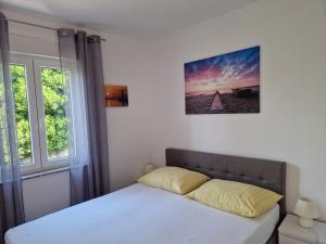 a bed in a bedroom with a large window at Apartment Elena in Dramalj